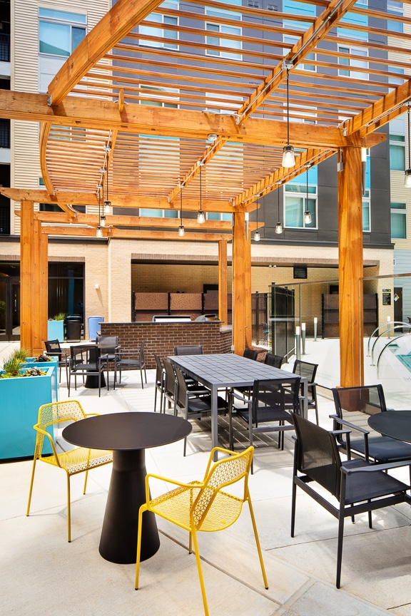 courtyard with social seating, tables and pergola at scout fairfax luxury apartments