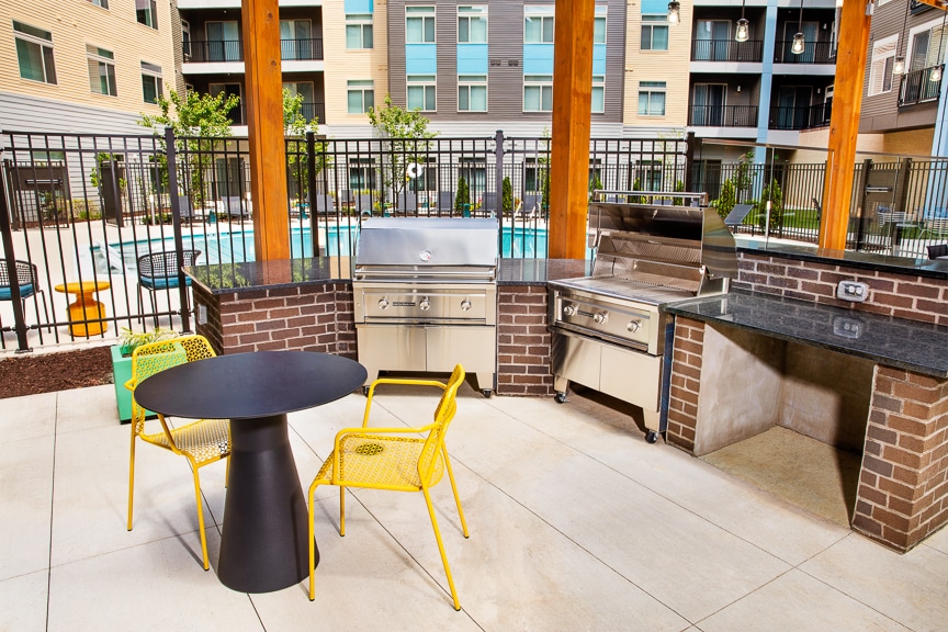 courtyard with social seating, grill stations and tables at scout fairfax luxury apartments