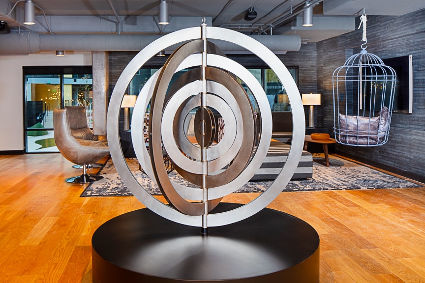 Metal gyroscope sculpture in a grey themed lounge at scout Fairfax luxury apartments