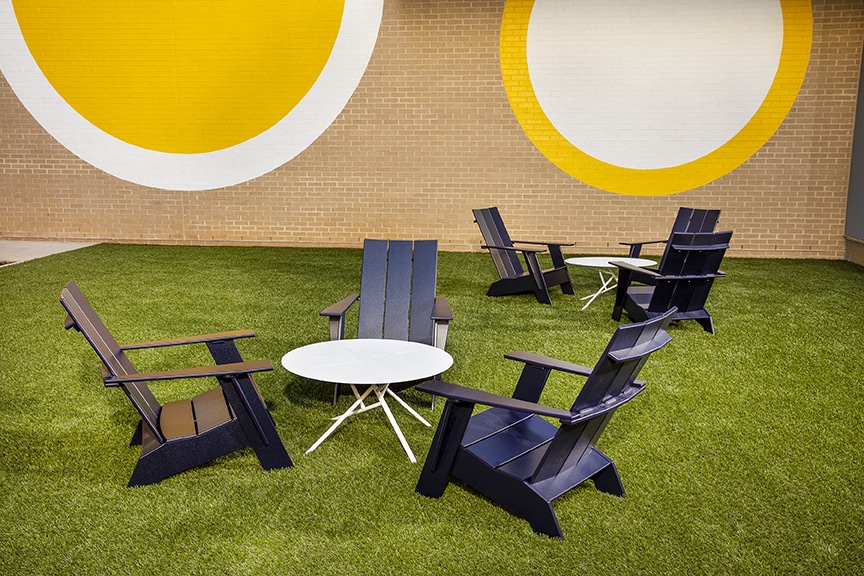 Yellow circular wall mural next to a social seating and cocktail tables at scout fairfax luxury apartments