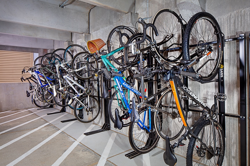 Bikes hanging on racks in a custom storage room at scout fairfax luxury apartments