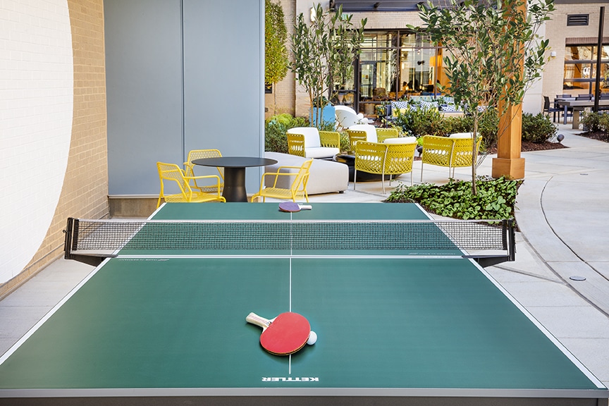 Ping pong table with outdoor lounge in the background at scout fairfax luxury apartments