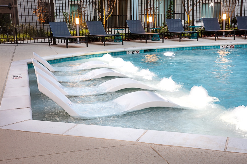 Close up of in-pool chaise lounge chairs at scout fairfax luxury apartments