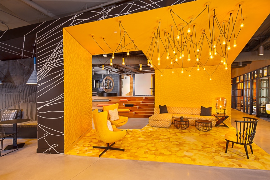 Yellow themed resident lounge with social seating, sofa, cocktail tables, and modern lighting at scout fairfax luxury apartments