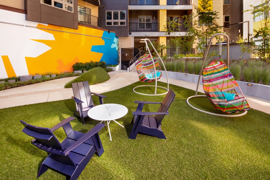 courtyard with social seating and colorful swing chairs at scout on the circle luxury fairfax apartments
