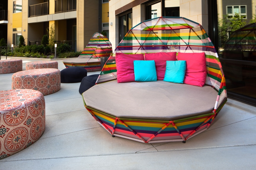 courtyard with social seating, colorful ottomans and colorful egg shaped sofas at scout on the circle luxury fairfax apartments