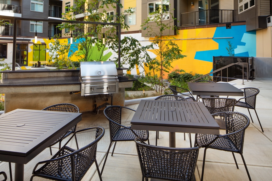 courtyard with social seating, colorful artwork, grill stations and views of apartment balconies at scout on the circle fairfax luxury apartments
